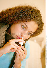WOMAN USING NOSE SPRAY