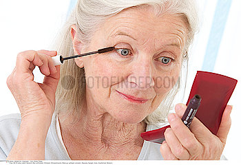 ELDERLY WOMAN PUTTING ON MAKE-UP