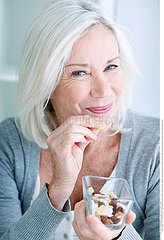 ELDERLY PERSON EATING DRIED FRUIT