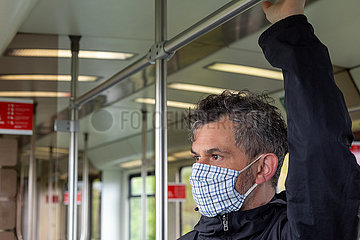 Berlin  Deutschland - Mann mit Schutzmaske in der Berliner S-Bahn