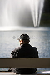 Deutschland  Bremen - Rentner sitzt an einem Teich im Buergerpark