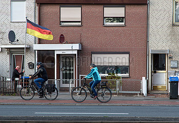 Deutschland  Bremen - Reihenhaeuser im Arbeiterbezirk Groepelingen beim Hafen  Anwohner justiert deutsche Fahne