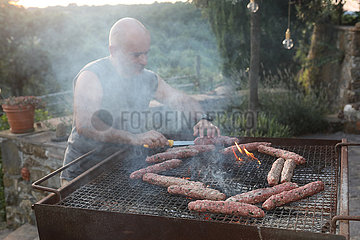 Pomantello  Italien  Mann bereitet Fleisch auf einem Grill zu
