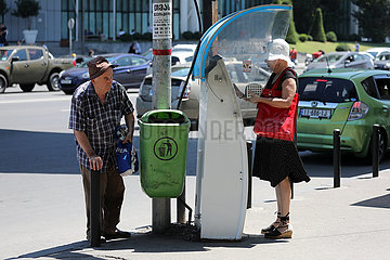 Tiflis  Georgien  alter Mann beobachtet eine gut gekleidete Frau beim Geldabheben