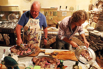 Pomantello  Italien  Maenner richten Steaks auf Silbertabletts an