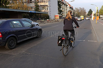Berlin  Deutschland  Fahrradfahrerin faehrt ohne Helm auf einer Strasse