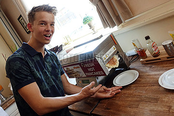 Langenhagen  Deutschland  Junge bereitet sich zum Fruehstueck Pancakes mit einem Automaten zu