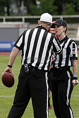 Berlin  Deutschland  Schiedsrichter beim American Football. Referee (weisse Kappe) und Line Judge beraten sich