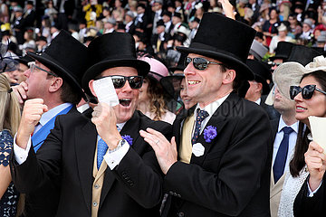 Ascot  Grossbritannien  elegant gekleidete Menschen fiebern auf der Galopprennbahn beim Pferderennen mit