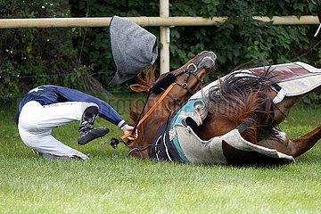 Hoppegarten  Deutschland  Galopprennpferd rutscht mit seinem Jockey an der Startstelle aus und faellt. Pferd und Reiter bleiben hierbei unverletzt