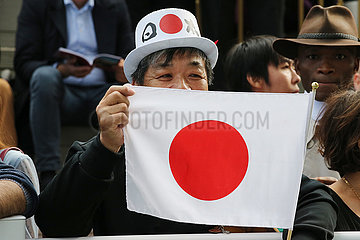 Paris  Frankreich  Asiate haelt eine japanische Nationalfahne in der Hand