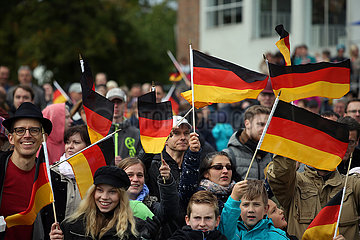 Hoppegarten  Deutschland  Menschen schwenken am Tag der Deutschen Einheit Nationalfahnen