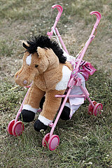 Magdeburg  Pluesch-Pferd sitzt in einem Puppenkinderwagen