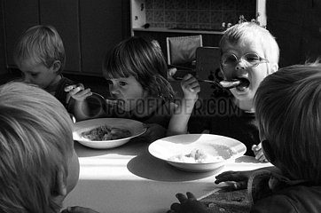 Berlin  Deutsche Demokratische Republik  Kleinkinder sitzen in einer Kinderkrippe zum Mittagessen an einem Tisch