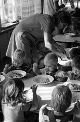 Berlin  Deutsche Demokratische Republik  Erzieherin hilft Kleinkindern in einer Kinderkrippe beim Mittagessen