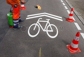 Neue Fahrradstrasse  ein Fahrbahnmarkierer beim Aufbringen der Fahrrad Piktogramme  Essen  Ruhrgebiet  Nordrhein-Westfalen  Deutschland