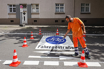 Neue Fahrradstrasse  ein Fahrbahnmarkierer beim Aufbringen der Fahrrad Piktogramme  Essen  Ruhrgebiet  Nordrhein-Westfalen  Deutschland