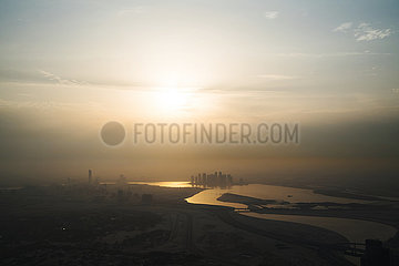 View from above on the Dubai Canal during sunrise with a thick layer of smog and air pollution