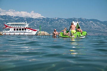 Kroatien  Rab  San Marino - Touristen mit Tretboot am Paradise Beach  links ein Ausflugsboot