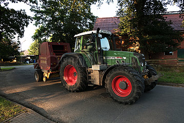 Deutschland  Heidenau - Landwirt unterwegs mit Traktor auf Dorfstrasse