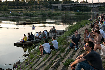 Polen  Poznan - Junge Leute am Rand eines Open-Air-Konzerts an der Warthe