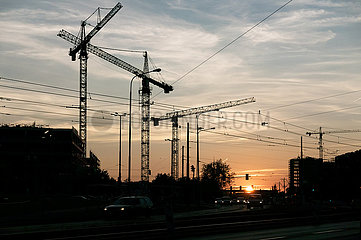 Polen  Poznan - Baukraene einer Gewerbeimmobilie in der Abendsonne
