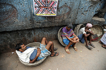 Kolkata (Kalkutta)  Indien  Tageloehner ruhen sich am Strassenrand im Stadtzentrum aus