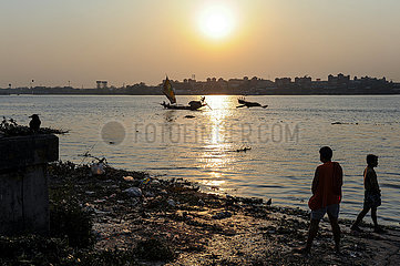 Kolkata (Kalkutta)  Indien  Menschen am Ufer des Hugli Fluss waehrend Sonnenuntergang
