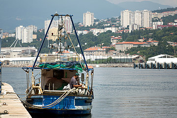 Kroatien  Rijeka - Fischer angelt im Hafen