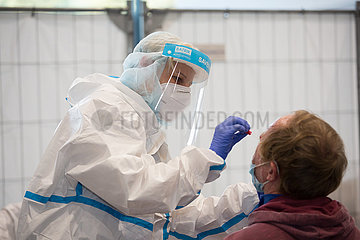 Deutschland  Bremen - Medizinische Fachangestellte Corona-Testzentrum in einer Messehalle macht einen Abstrich bei einem Mann