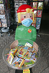 Berlin  Deutschland  Pixiefigur mit Mund-Nasen-Schutz vor einem Schreibwarenladen