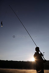 Dranse  Deutschland  Silhouette: Jugendlicher angelt bei Sonnenaufgang in einem See