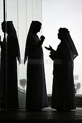 Dubai  Vereinigte Arabische Emirate  Silhouette  Maenner in Landestracht unterhalten sich