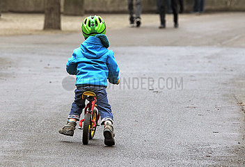 Berlin  Deutschland  Kleinkind faehrt mit einem Laufrad auf einem Gehweg