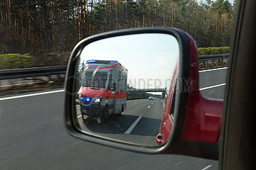 Michendorf  Deutschland  Rettungswagen der Johanniter auf der A10 im linken Rueckspiegel eines PKW