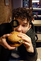Berlin  Deutschland  Junge isst einen Hamburger