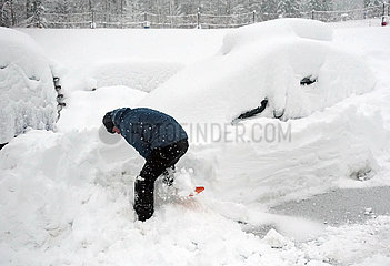 Krippenbrunn  Oesterreich  Skiurlauber befreit sein eingeschneites Auto von den Schneemassen