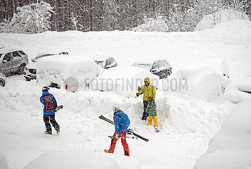 Krippenbrunn  Oesterreich  Skiurlauber suchen auf einem Parkplatz ihr eingeschneites Auto