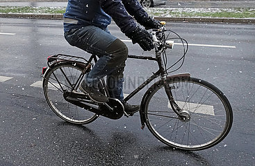 Berlin  Deutschland  Radfahrer faehrt im Winter auf einer Strasse