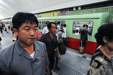 Pjoengjang  Nordkorea  Pendler auf Bahnsteig einer Haltestelle mit wartender U-Bahn der Metro Pjoengjang