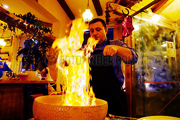 Berlin  Deutschland  Koch flambiert in einem Restaurant Spaghetti in einem ausgehoehlten Parmesanlaib