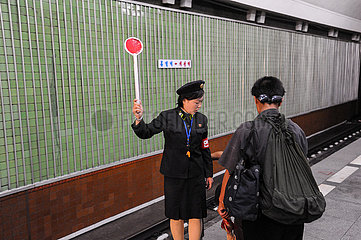 Pjoengjang  Nordkorea  Aufseherin mit Haltekelle am Bahnsteig einer U-Bahnhaltestelle der Metro Pjoengjang
