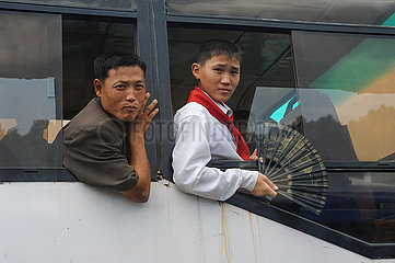 Pjoengjang  Nordkorea  Mann und Junge schauen aus dem offenen Fenster eines Busses