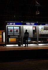 Koeln  Deutschland  Reisender in der Nacht allein auf einem Bahnsteig im Hauptbahnhof
