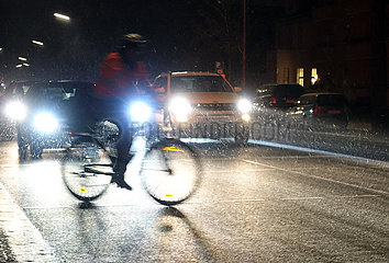 Berlin  Deutschland  Radfahrer und Autos bei Schneefall in der Nacht