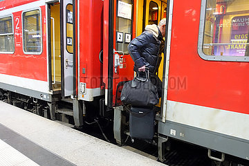 Berlin  Deutschland  Mann steigt mit Gepaeck in einen Zug ein