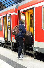 Berlin  Deutschland  Mann steigt mit Gepaeck in einen Zug ein