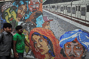 Kolkata (Kalkutta)  Indien  Maenner gehen an einem Wandmosaik vor einer U-Bahnstation vorbei