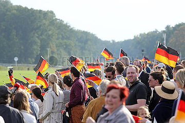 Hoppegarten  Deutschland  Menschen schwenken am Tag der Deutschen Einheit Nationalfahnen