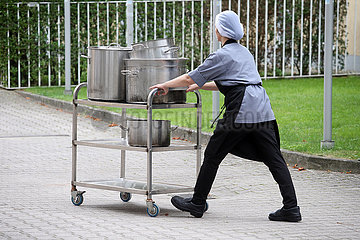 Iffezheim  Deutschland  Kuechenhilfe schiebt einen Servierwagen mit riesigen Kochtoepfen